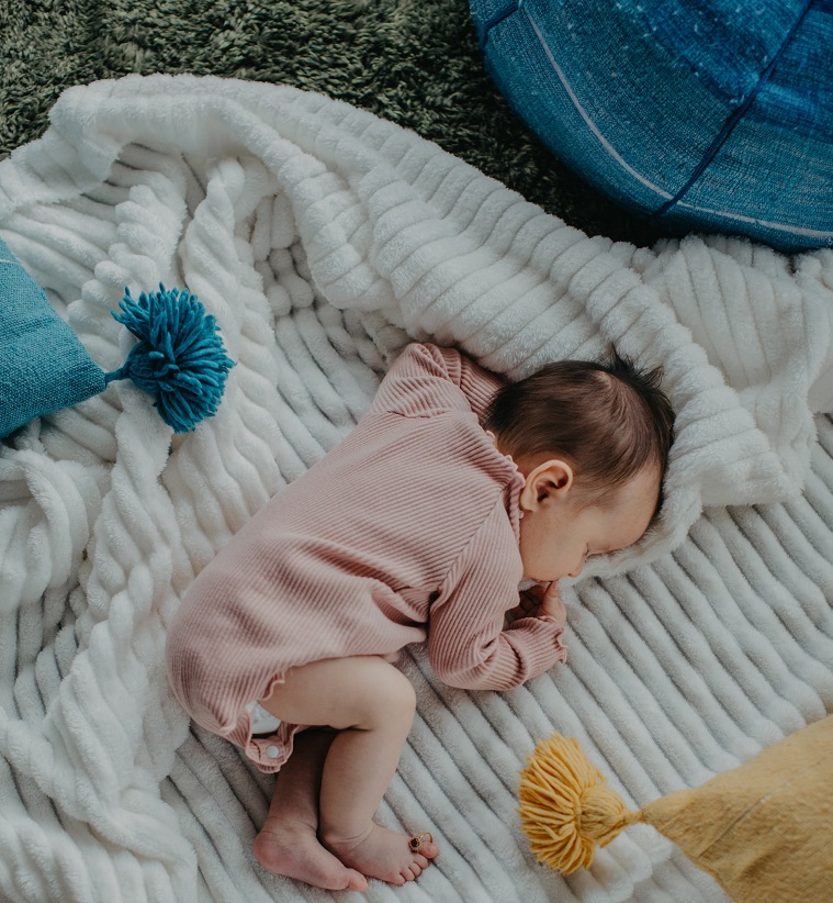 picture of a baby lying on a blanket on the ground