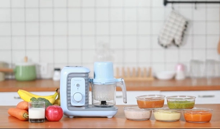 baby food maker on counter surrounded by vegetables 