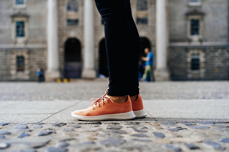 picture of a woman legs in sneakers and black pants standing on the ground 