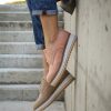 picture of woman legs wearing jeans and comfortable women shoes beside concrete stairs