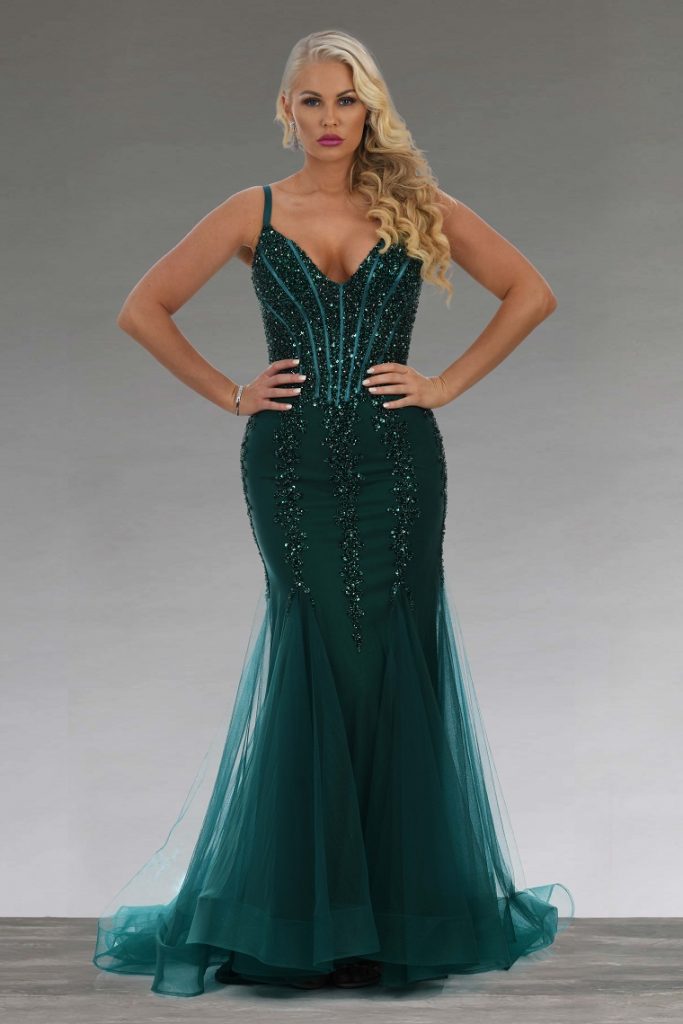 picture of a woman wearing green sequin corset dress in front a gray background 