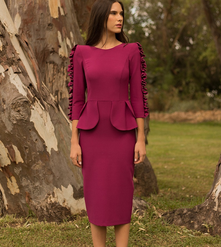 picture of a woman in purple peplum dress beside a tree standing on a grass 