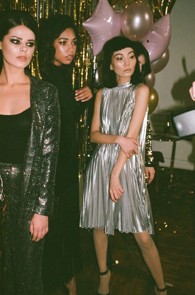 picture of a woman in silver dress beside other women in sequin black suit 
