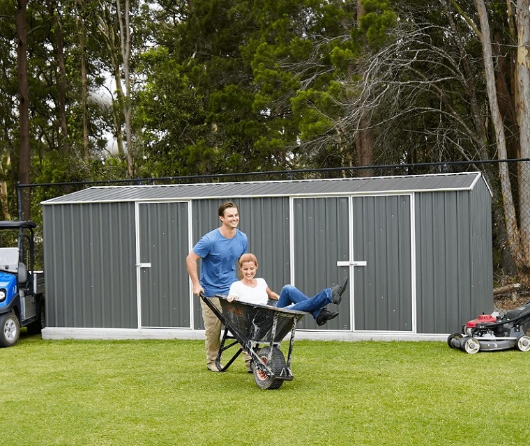 couple having fun in front of large garden shed