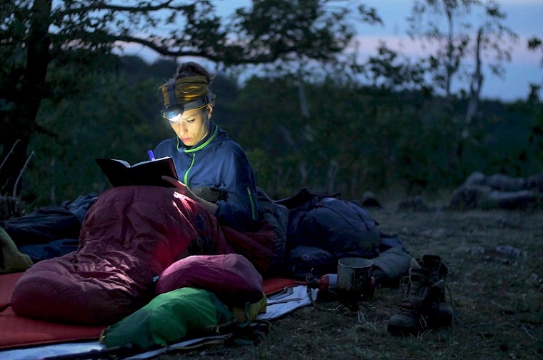 woman using headlamp to read