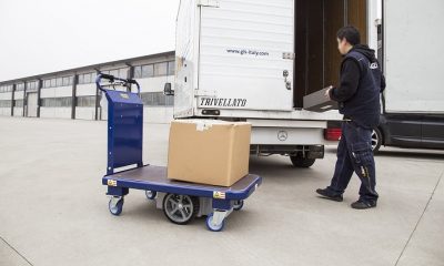 Electric platform trolley with load by the van and woker