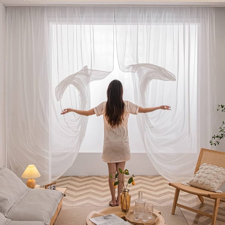 woman throwing the curtains of the window 