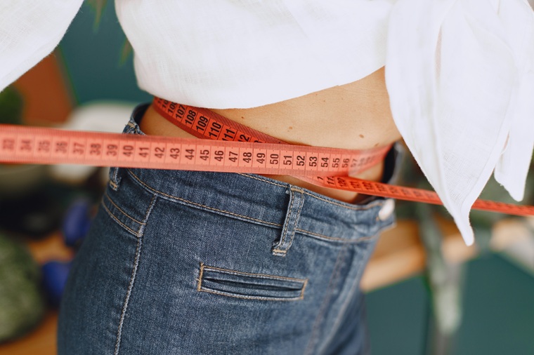 woman measuring her waist